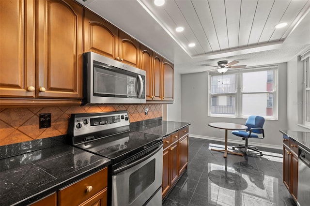 kitchen featuring appliances with stainless steel finishes, tasteful backsplash, a raised ceiling, and ceiling fan