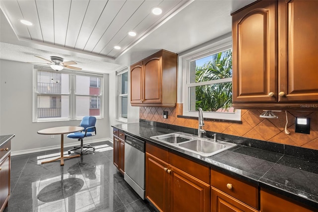 kitchen featuring dishwasher, sink, ceiling fan, dark tile patterned floors, and tasteful backsplash