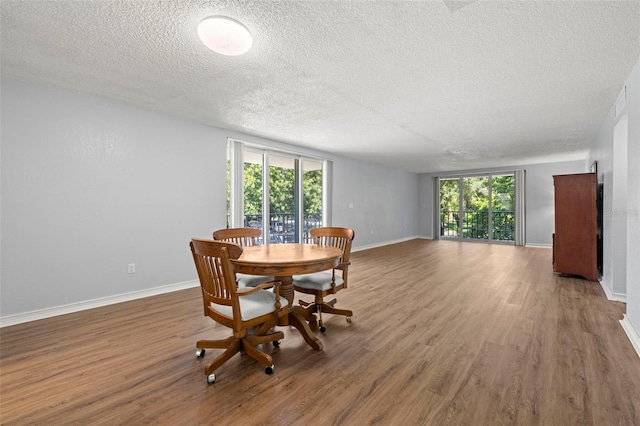 dining area with a healthy amount of sunlight, dark hardwood / wood-style floors, and a textured ceiling