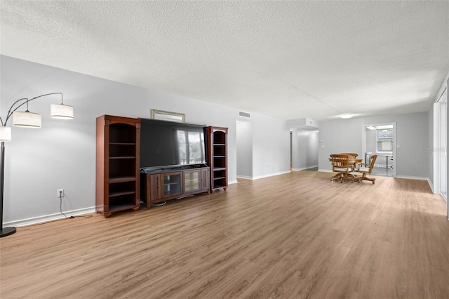 unfurnished living room featuring hardwood / wood-style floors and a textured ceiling