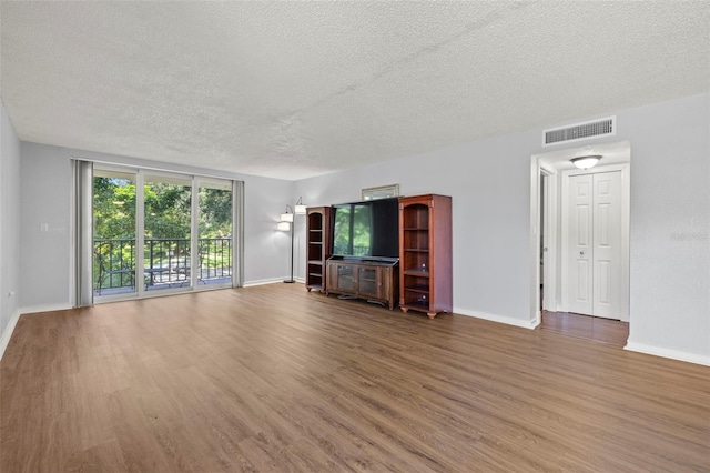 unfurnished living room with a textured ceiling and hardwood / wood-style flooring