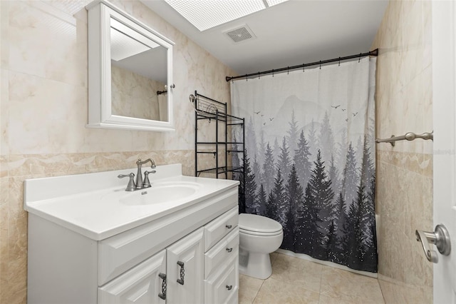 bathroom with tile patterned flooring, toilet, vanity, tile walls, and a shower with shower curtain