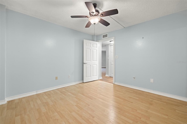 unfurnished room with ceiling fan, light wood-type flooring, and a textured ceiling