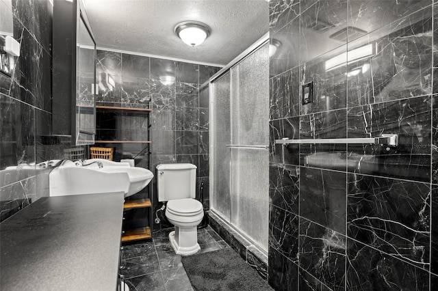 bathroom with a textured ceiling, toilet, a shower with door, and tile walls