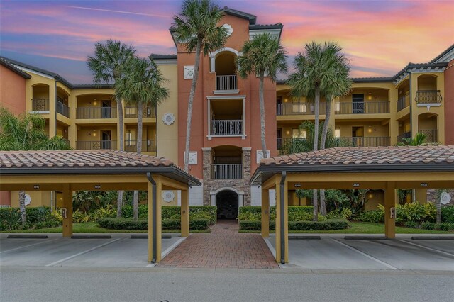 property at dusk featuring covered parking