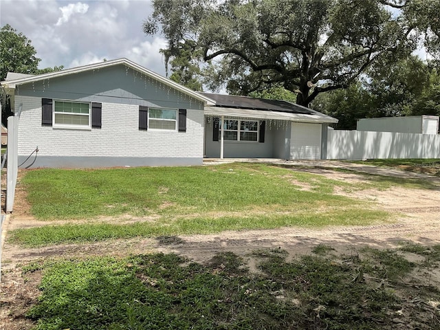 rear view of house featuring a yard and solar panels