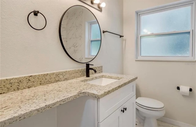 bathroom with vanity, toilet, and plenty of natural light