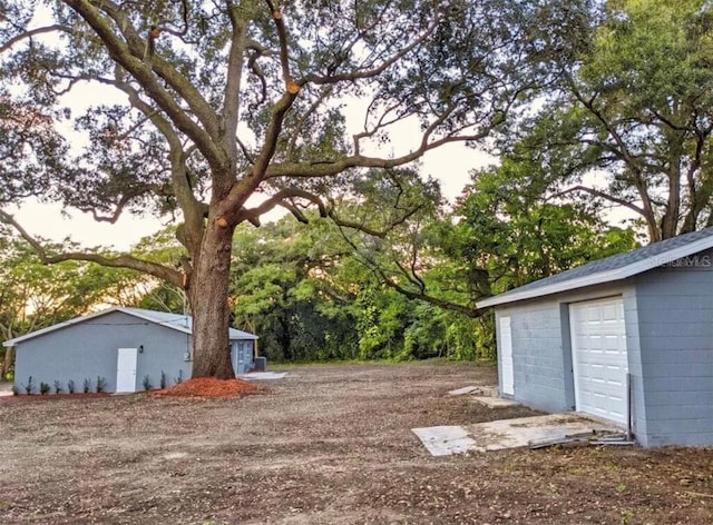 view of yard with a garage and an outbuilding