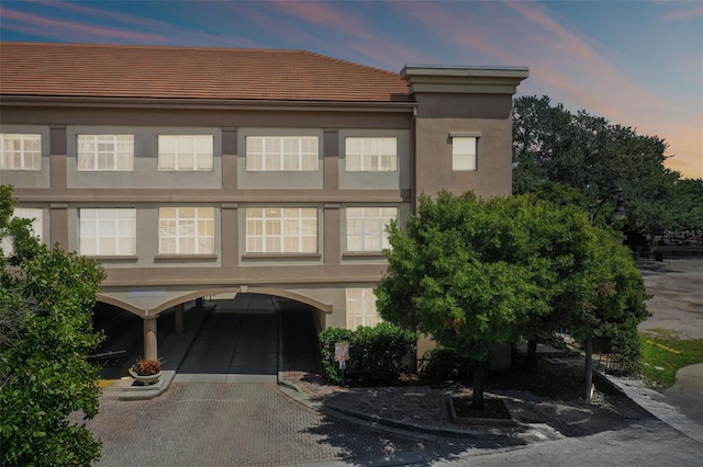 view of front of house featuring a garage, decorative driveway, and stucco siding