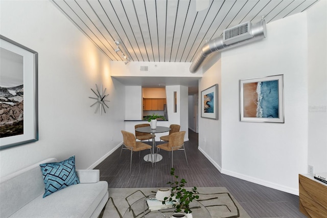 interior space featuring baseboards, visible vents, track lighting, and wood finish floors