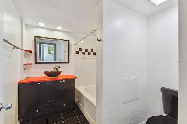 full bathroom featuring tiled shower / bath combo, vanity, toilet, and tile patterned flooring