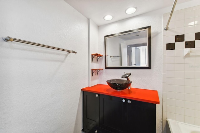 bathroom featuring tiled shower / bath and vanity