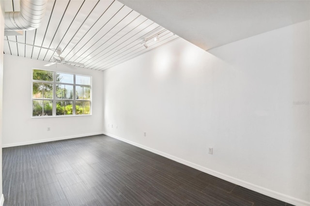 unfurnished room with dark wood-style floors, baseboards, and a ceiling fan