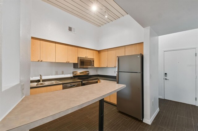 kitchen featuring stainless steel appliances, sink, and light brown cabinets