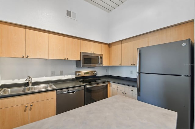 kitchen featuring stainless steel appliances, sink, and light brown cabinets