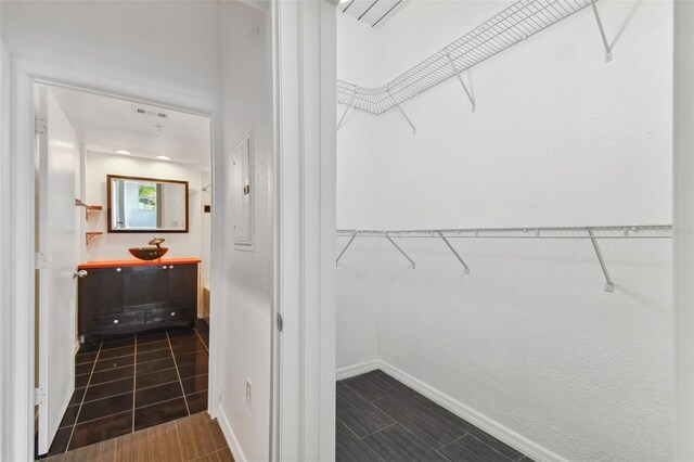 walk in closet with dark tile patterned floors