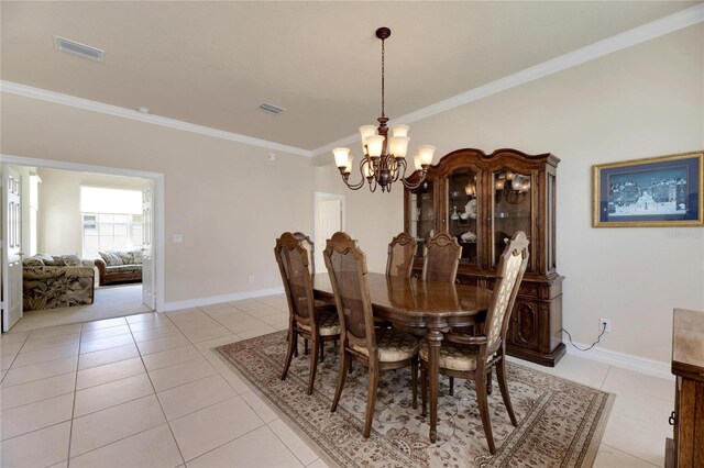 tiled dining room with crown molding and an inviting chandelier