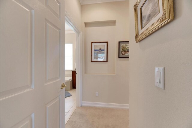 corridor featuring light carpet and ornamental molding