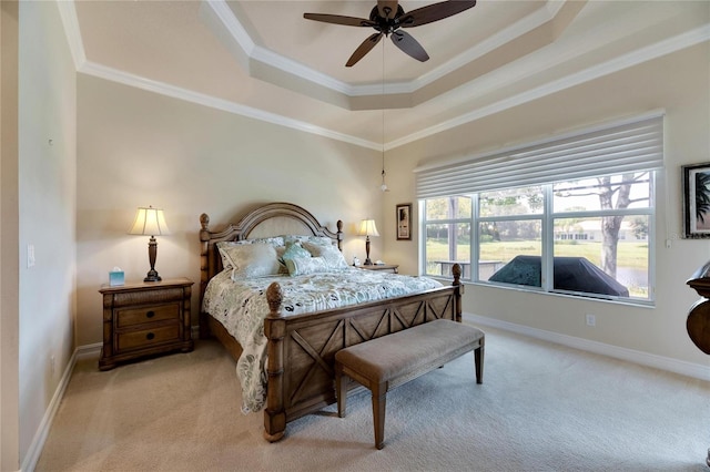 bedroom featuring ceiling fan, light colored carpet, crown molding, and a tray ceiling