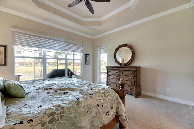 bedroom with carpet flooring, ceiling fan, crown molding, and a tray ceiling