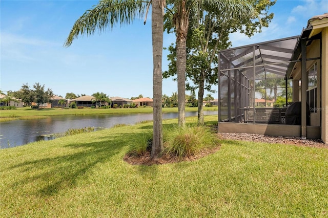 view of yard featuring a lanai and a water view