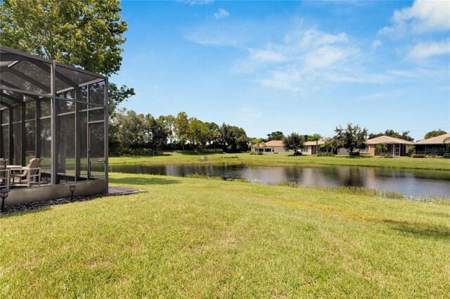 view of yard featuring a lanai and a water view