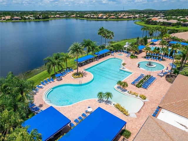 view of pool featuring a community hot tub, a water view, and a patio