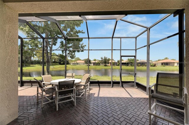 sunroom featuring a water view