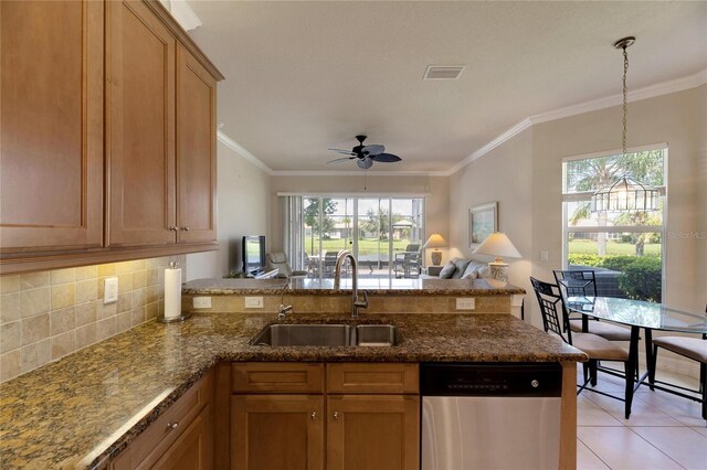 kitchen with kitchen peninsula, dishwasher, a healthy amount of sunlight, and sink