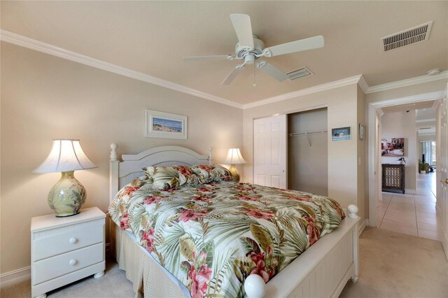 bedroom featuring ceiling fan, light colored carpet, ornamental molding, and a closet