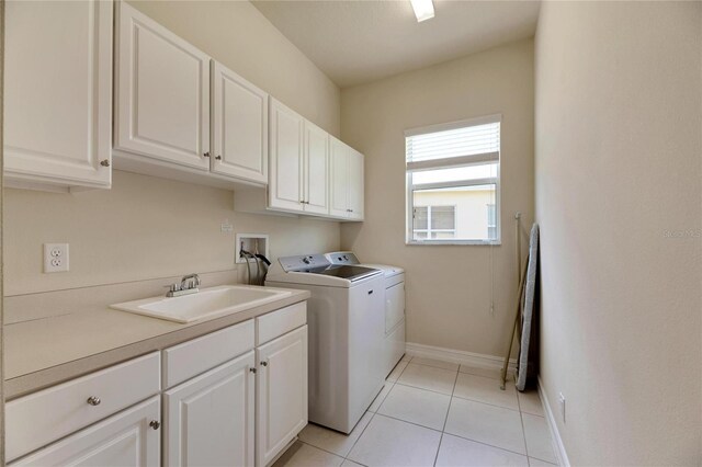 laundry area with light tile patterned flooring, cabinets, sink, and washing machine and dryer