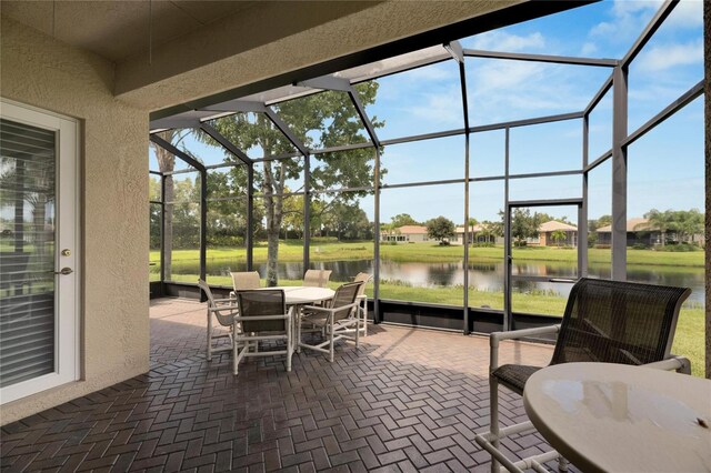 sunroom / solarium featuring a water view