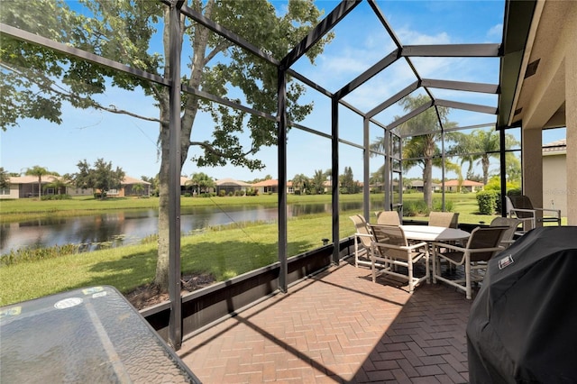 sunroom featuring a water view and lofted ceiling