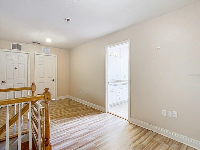 empty room featuring light wood-type flooring and sink