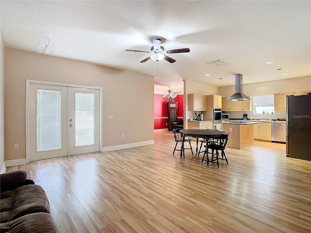 dining room featuring french doors, ceiling fan with notable chandelier, light hardwood / wood-style floors, and sink