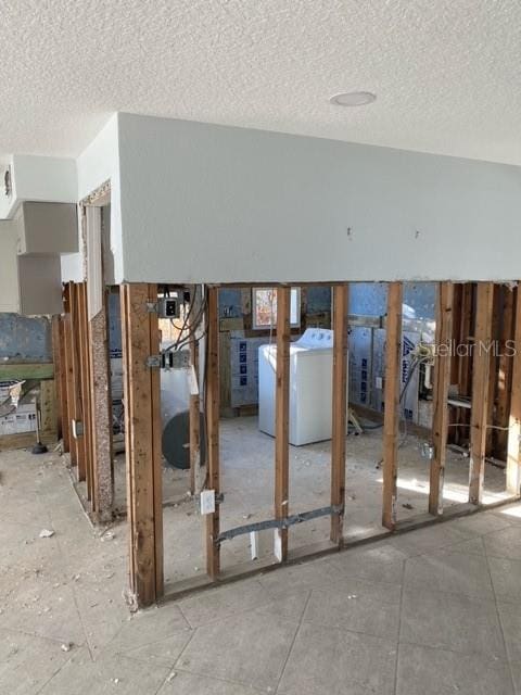 interior space with a textured ceiling and washer / clothes dryer