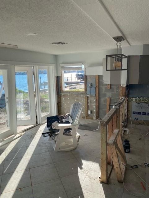 interior space featuring light tile patterned floors and a textured ceiling