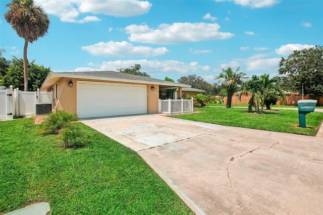 ranch-style home featuring a front lawn, a garage, and central air condition unit