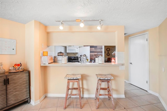 kitchen with a textured ceiling, a kitchen bar, kitchen peninsula, black electric range oven, and track lighting