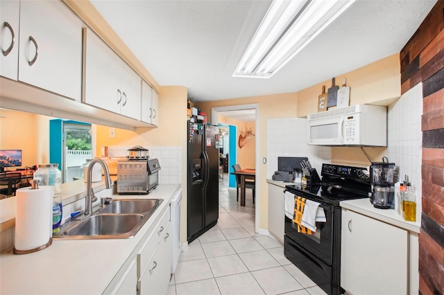 kitchen with black appliances, light tile patterned floors, sink, and white cabinets