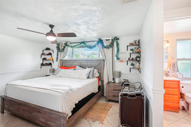 bedroom with a textured ceiling, ceiling fan, and light tile patterned floors