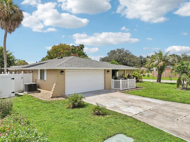 ranch-style home with a garage, a front yard, and central air condition unit