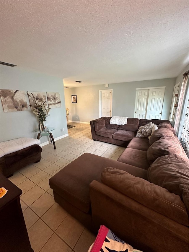 tiled living room featuring a textured ceiling