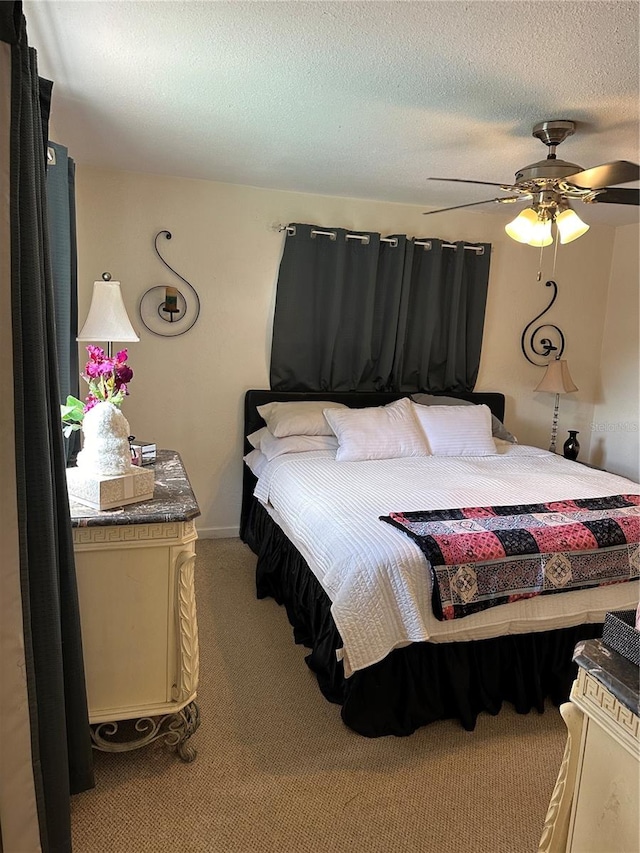 bedroom featuring a textured ceiling, light colored carpet, and ceiling fan