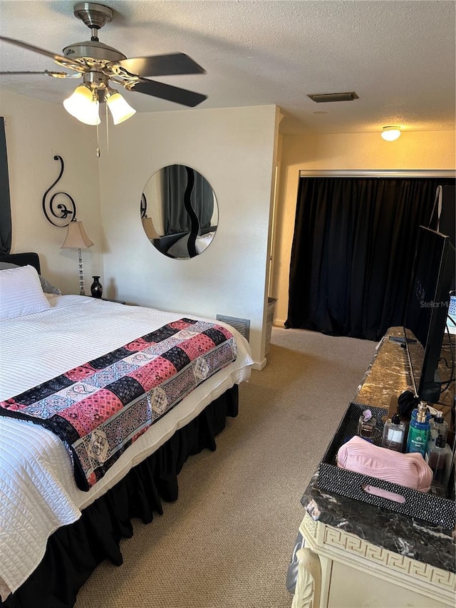 carpeted bedroom featuring a textured ceiling and ceiling fan