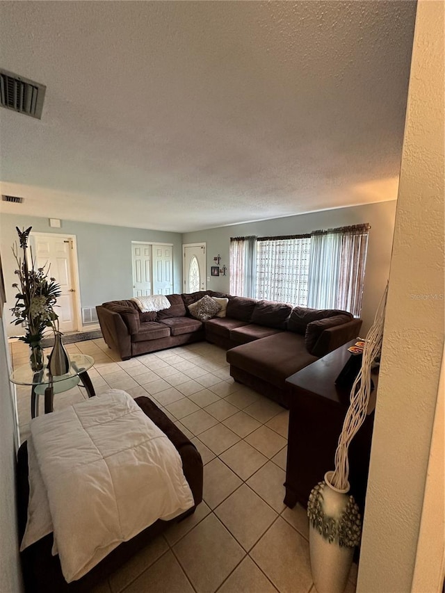 living room featuring a textured ceiling and light tile patterned floors