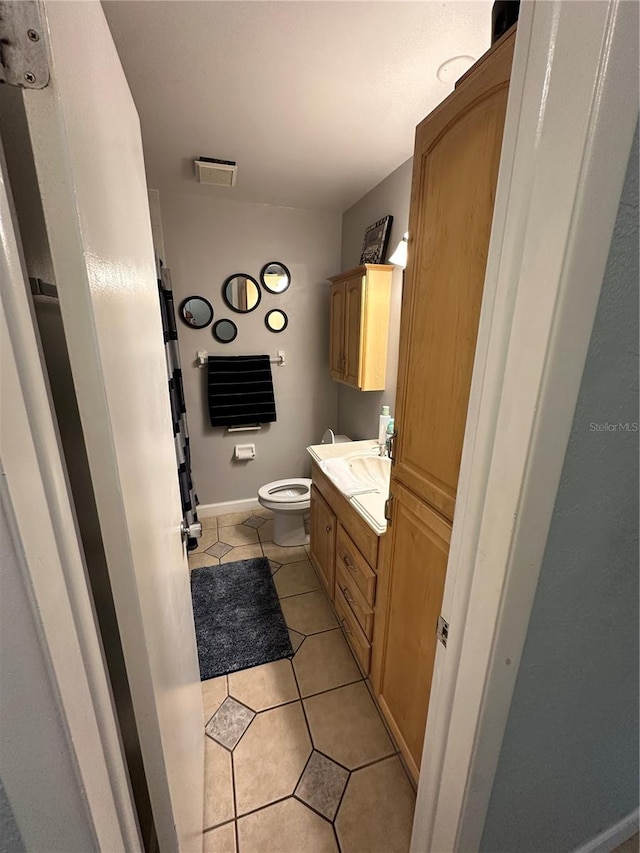 bathroom featuring vanity, toilet, and tile patterned flooring