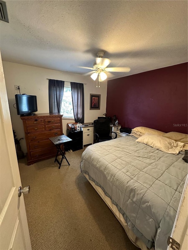 carpeted bedroom with a textured ceiling and ceiling fan