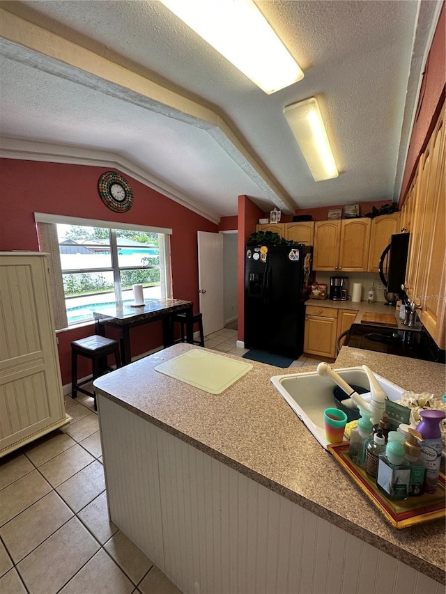 kitchen with a textured ceiling, vaulted ceiling, black appliances, light tile patterned floors, and crown molding