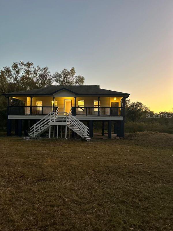 back house at dusk featuring a deck